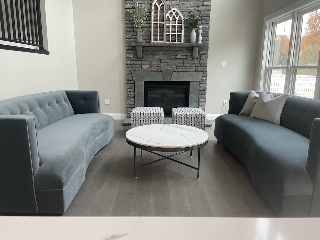 remodeled living room with a monochrome grey color to match the furniture and fireplace