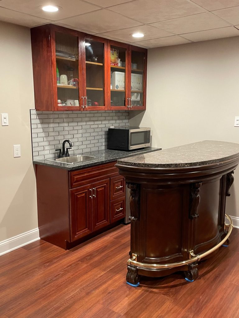small basement bar with a counter and appliances for simple food and drink serving