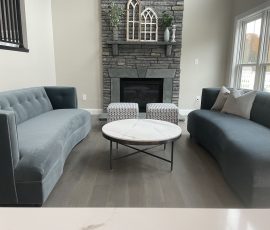 remodeled living room with a monochrome grey color to match the furniture and fireplace