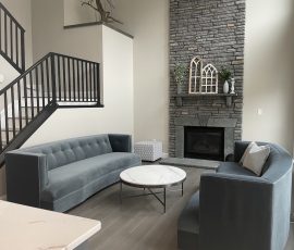 remodeled living room with a monochrome grey color to match the furniture and fireplace