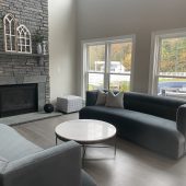 remodeled living room with a monochrome grey color to match the furniture and fireplace