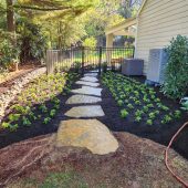 natural stone pathway wrapping around a house from the backyard patio to the front