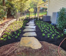 natural stone pathway wrapping around a house from the backyard patio to the front